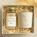 Gift set that includes a candle with a engraved flower design that reads I love you mom and a glass jar with a gold lid that contains white tipped wooden matches. The match jar has a white label that reads to my guiding light. 