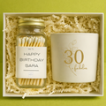 Gift set with jar of matches and candle in a box on a green background