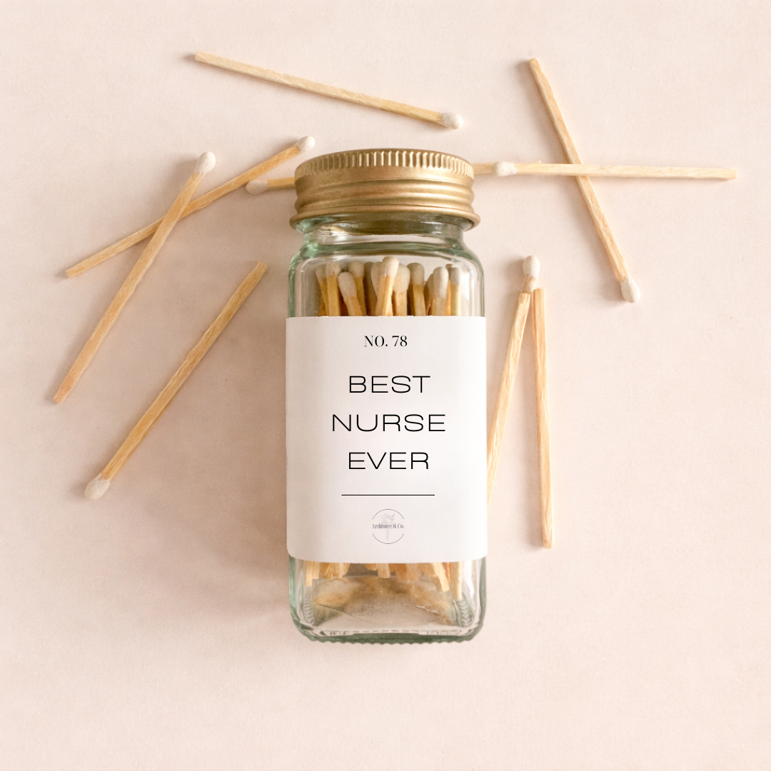 Gift box containing a glass jar of matches that say best nurse ever on the label and a candle that has a heart shaped stethascope and sara rn engraved on it