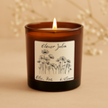 Candle in an amber jar with a decorative label on a beige background