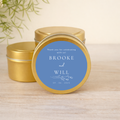 Gold tins with blue labels featuring personalized text on a wooden surface.