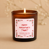 Amber glass candle with a pink Galentine's Day label on a beige background